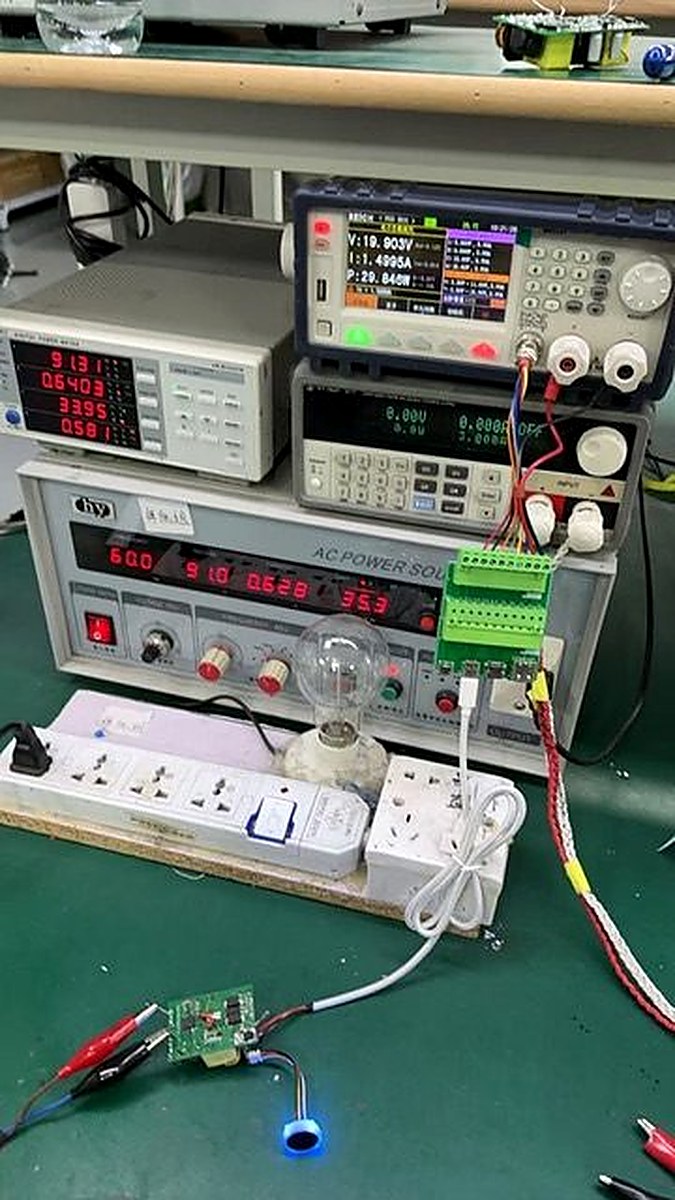 Charlie Charger PCB under test on factory bench with power analyzer, AC power source, and electronic load