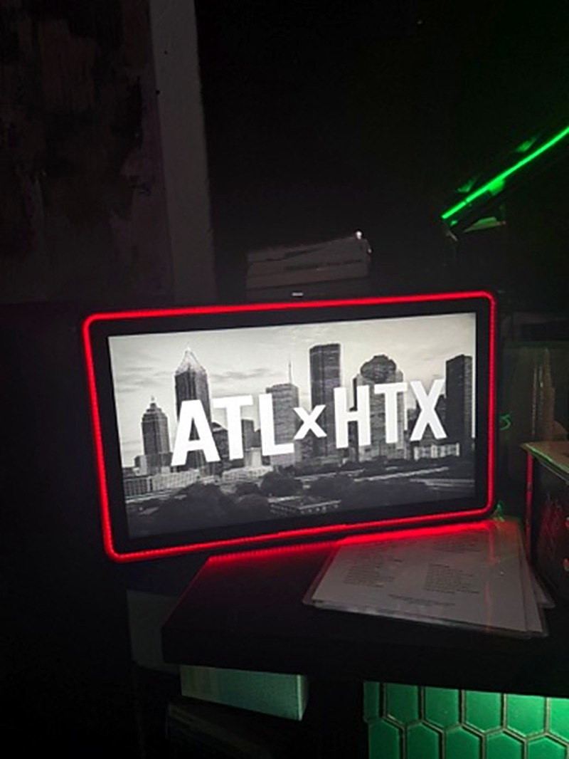 Genboard deployed in a nightclub with red RGB lighting showing ATLxHTX event content